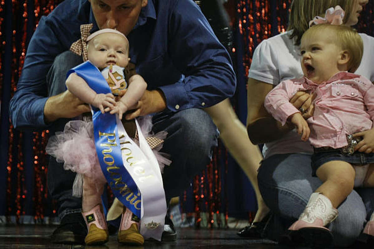 Ryan Serett kisses his three-month old daughter Brooke during the Baby Miss Rodeo category of the Pasadena Rodeo Beauty Pageant at the Pasadena Fairgrounds. Contestants in age groups all the way from babies to 18+ competed in the pageant. Winners will participate in the Pasadena Rodeo parade next weekend.