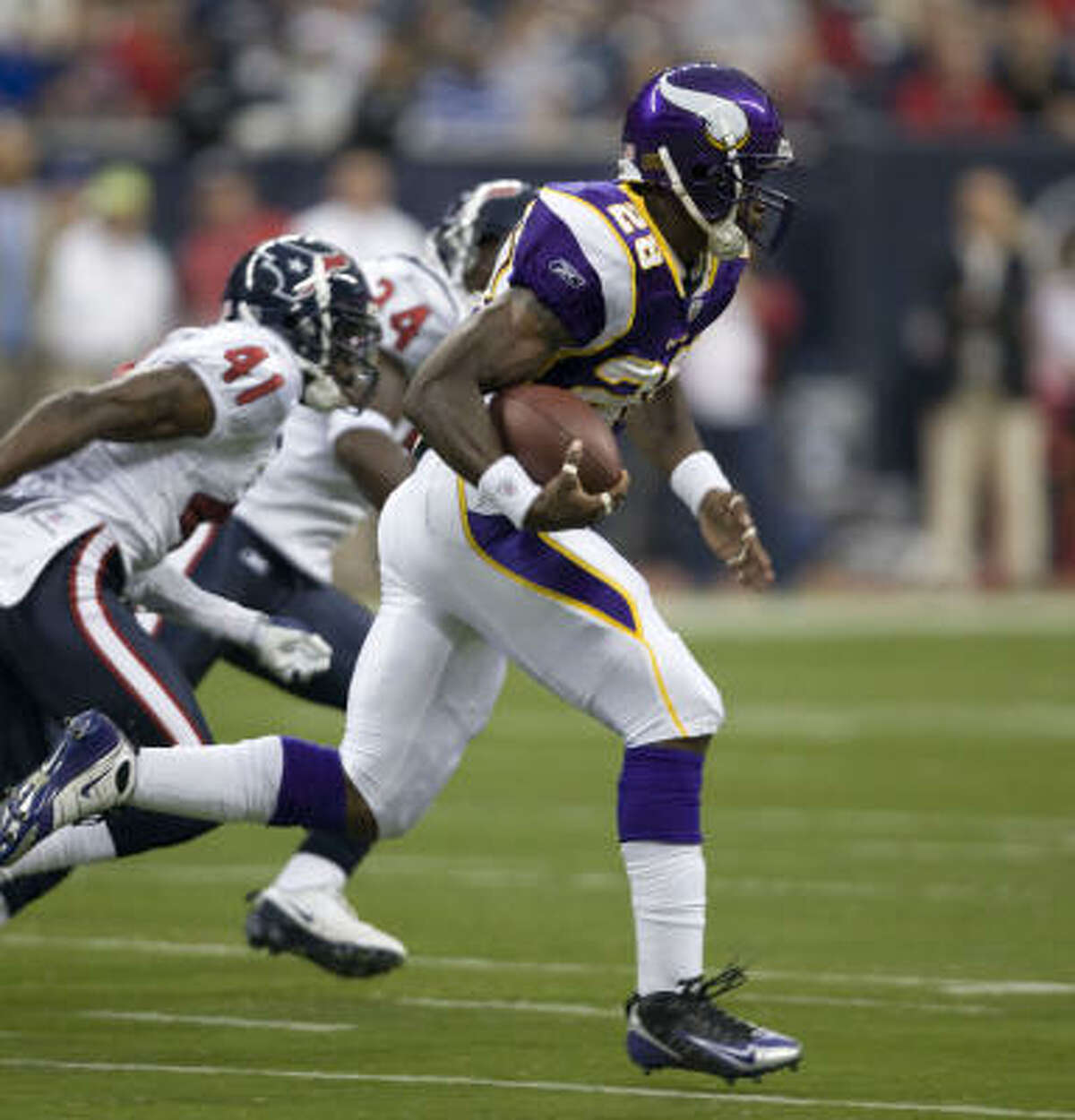 Minnesota Vikings running back Adrian Peterson races past Texans cornerback Brice McCain on his way to a 75-yard touchdown run on the first play from scrimmage.