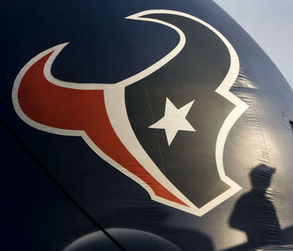 A fan casts a shadow on an giant Texans helmet during a training camp workout Thursday, Aug. 6, 2009.