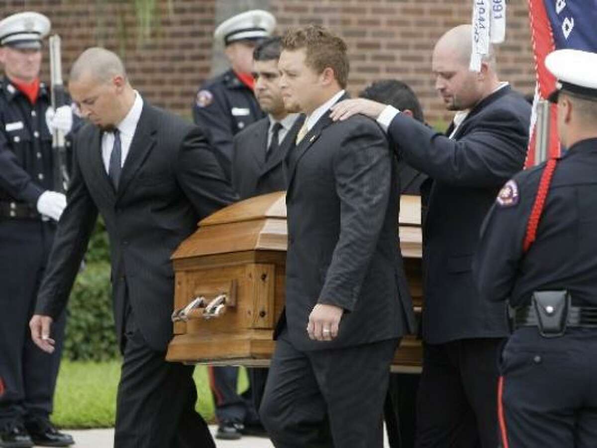 The casket of Pasadena Police officer Jesse Hamilton, 29, is carried after funeral service by pallbearers including his brother Chance Hamilton, front center, and Josh Doiron, front right.