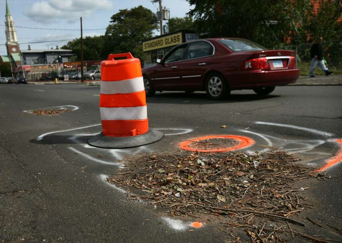 A traffic cone marks a hazardous section of roadway on State Street near Iranistan Avenue on Bridgeport's West Side on Thursday, October 8, 2009.