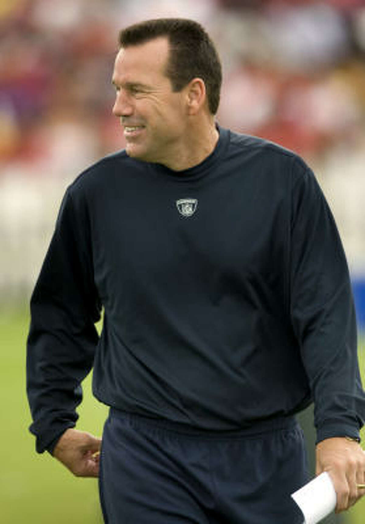 Texans coach Gary Kubiak smiles as he walks between drills.