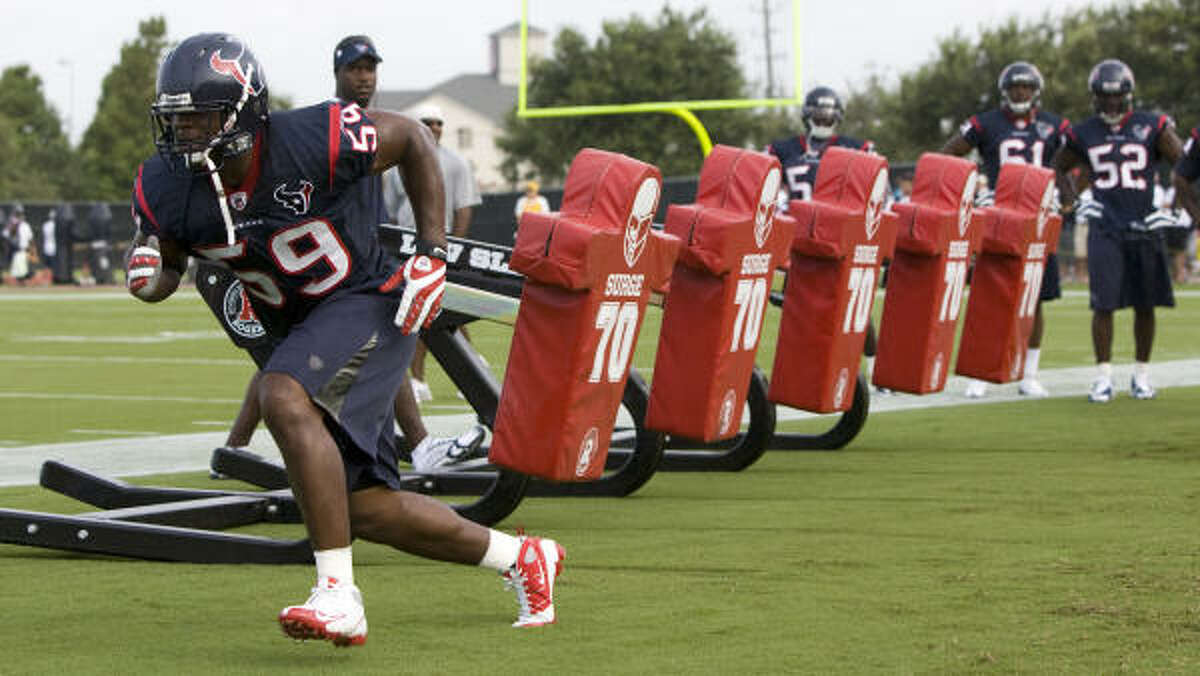 Texans linebacker DeMeco Ryans runs away from a blocking sled while working on drills.