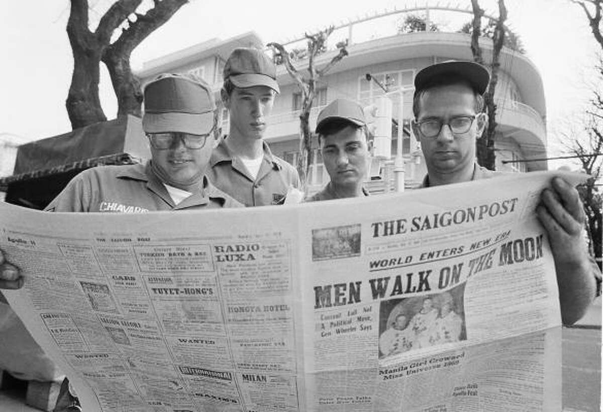 American servicemen pause on a downtown Saigon Street to read a local newspaper account of the Apollo 11 lunar landing, July 21, 1969, Ho Chi Minh City, Vietnam. From left are Air Force. Sgt. Michael Chivaris, Clinton, Mass., Army Spec. 4 Andrew Hutchins, Middlebury, Vt.; Air Force Sgt. John Whalin, Indianapolis, Ind.; and Army Spec. 4 Lloyd Newton, Roseburg, Ore.