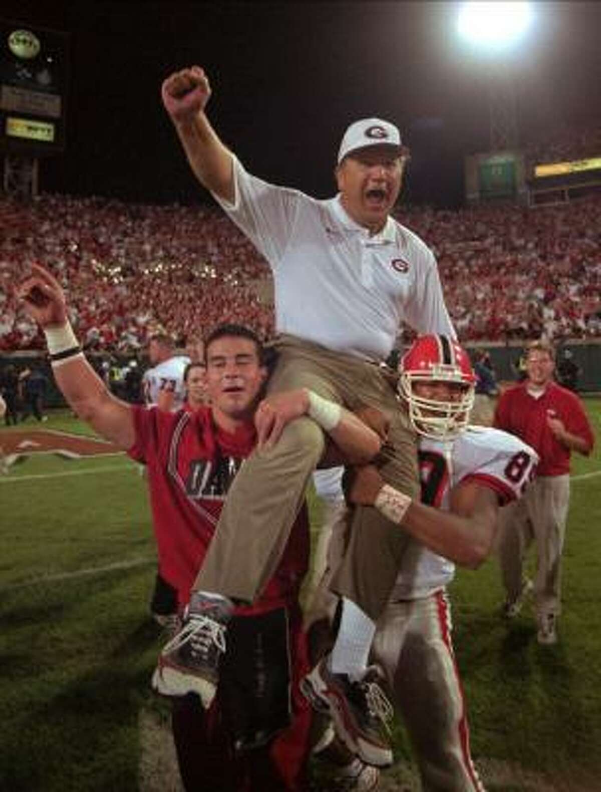 FILE -- Georgia tight end Jermaine Wiggins (89) and a cheerleader lift head coach Jim Donnan after his Bulldogs defeated the Florida Gators 37-17 in Jacksonville, Fla., in this Nov. 1, 1997 photo. This used to be the most frightening game on Georgia's schedule. Not anymore.
