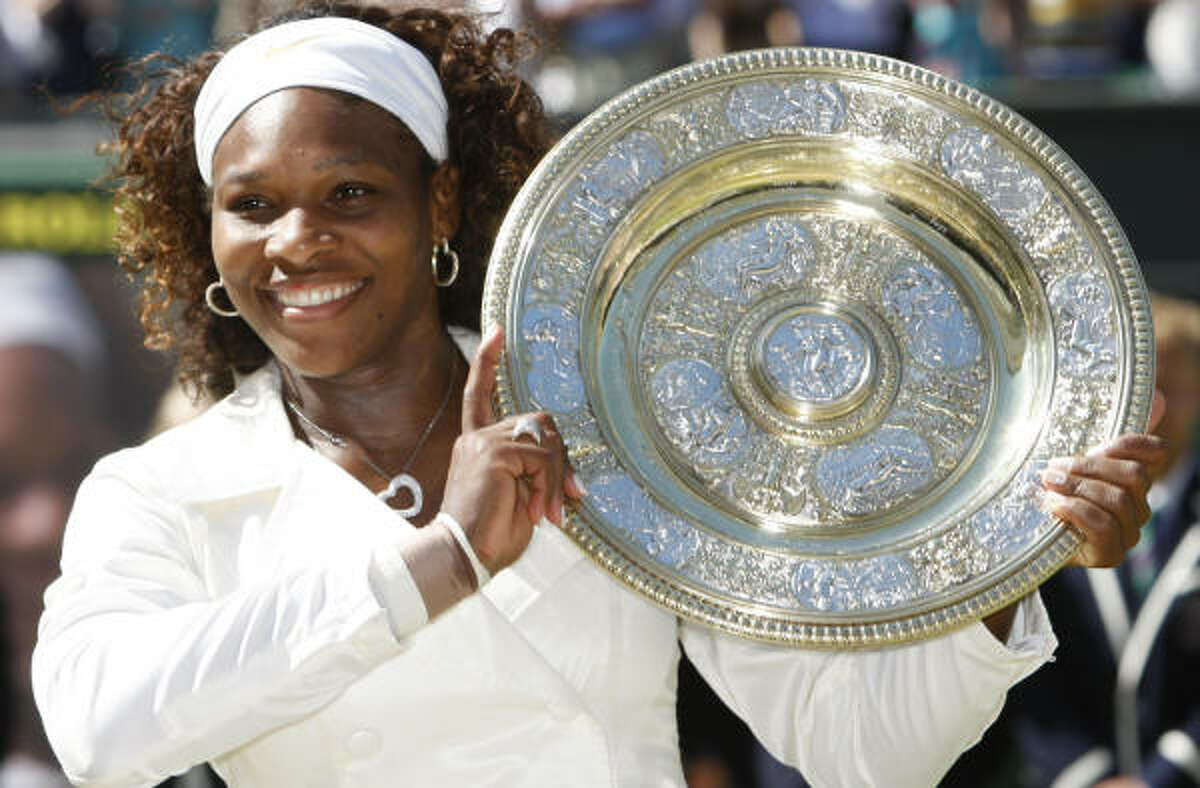 Serena Williams holds the championship trophy after winning her third Wimbledon title.