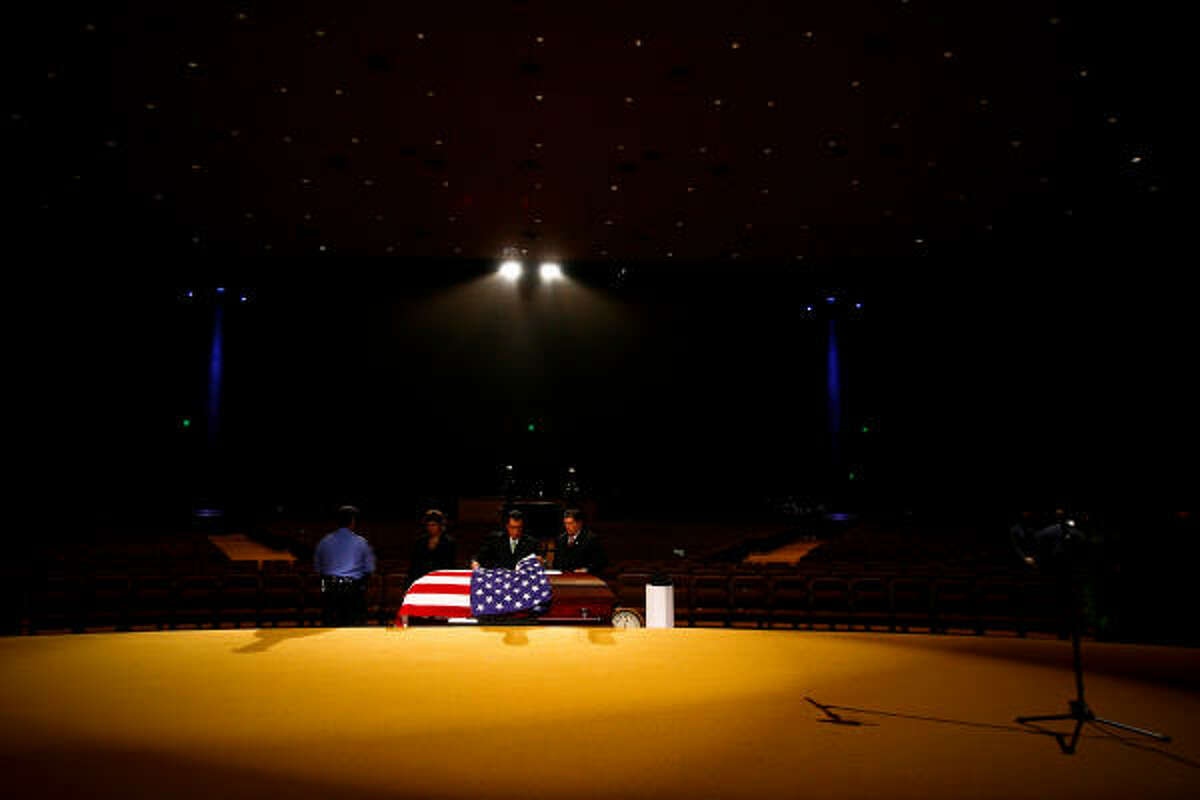 A police officer stands guard as attendants prepare the casket of HPD Senior Police Officer Henry Canales, 42, during funeral services for the fallen officer at Grace Community Church.