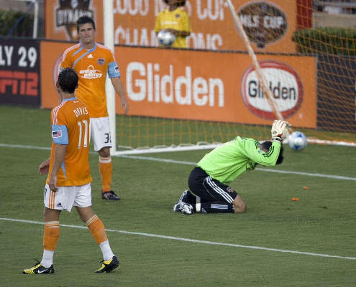 The Houston Dynamo's goalkeeper Pat Onstad (right) reacts after a goal is scored against him as teammates Brad Davis (left) and Bobby Boswell (center) look on.
