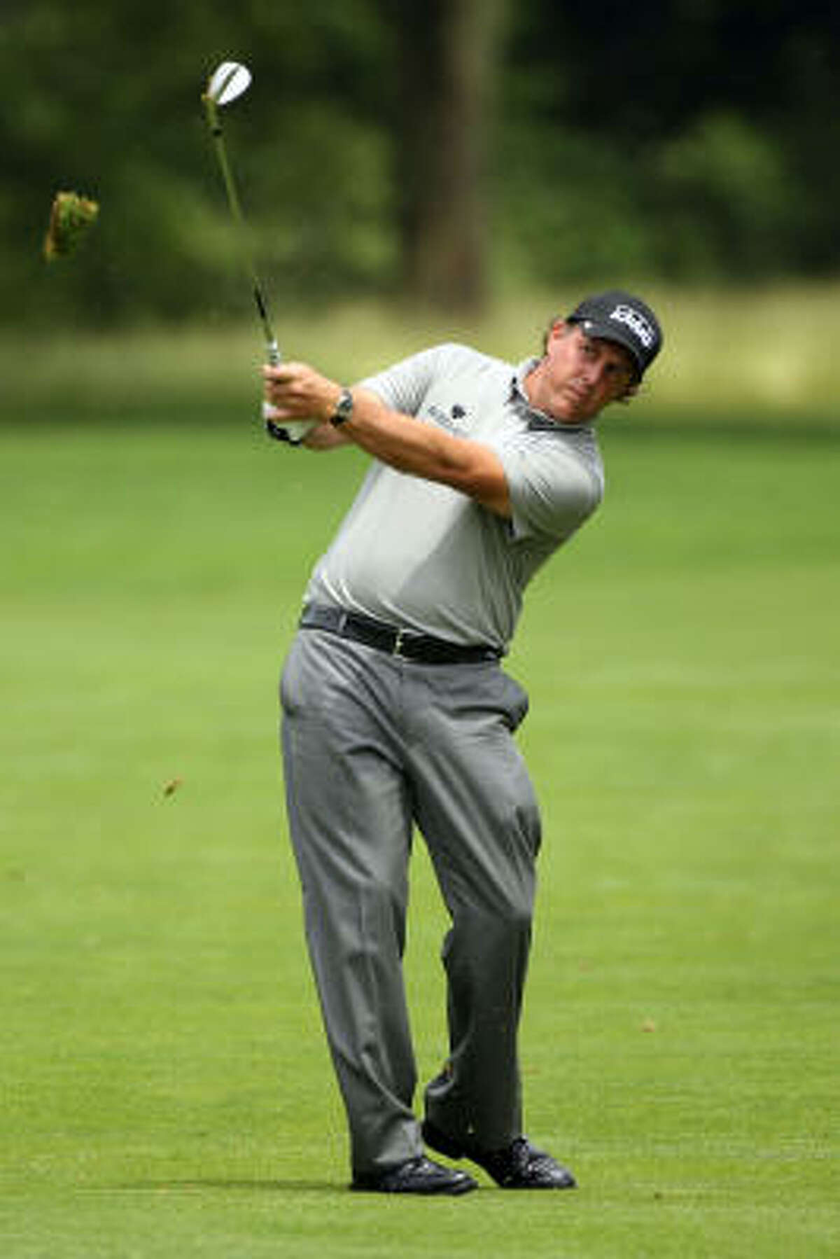 Phil Mickelson hits his approach shot on the 16th hole.