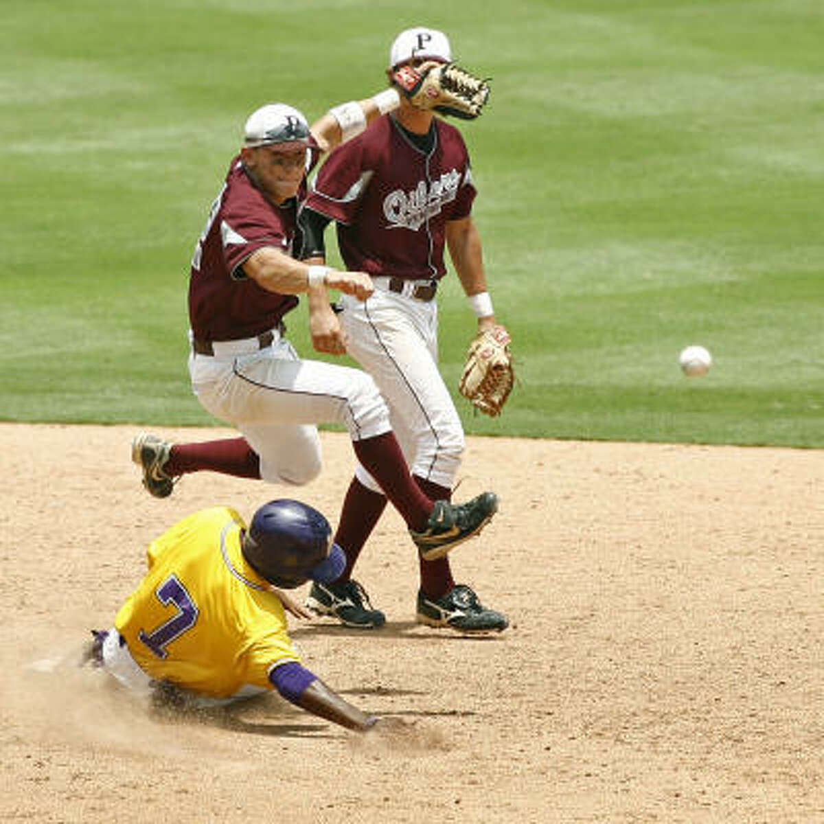 Pearland short stop Josh Gonzales (12) attempts a double play over Lufkin player Carrington Byndon (7) in the UIL 5A state baseball semifinal in Round Rock.