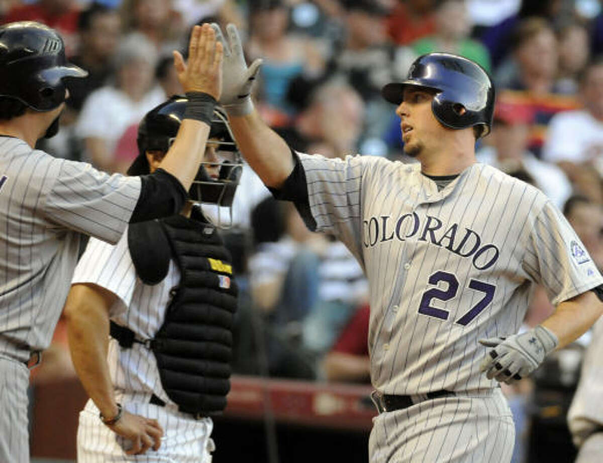 Colorado's Garrett Atkins, right, is greeted at home plate by teammate Todd Helton after hitting a two-run home run in the third inning.