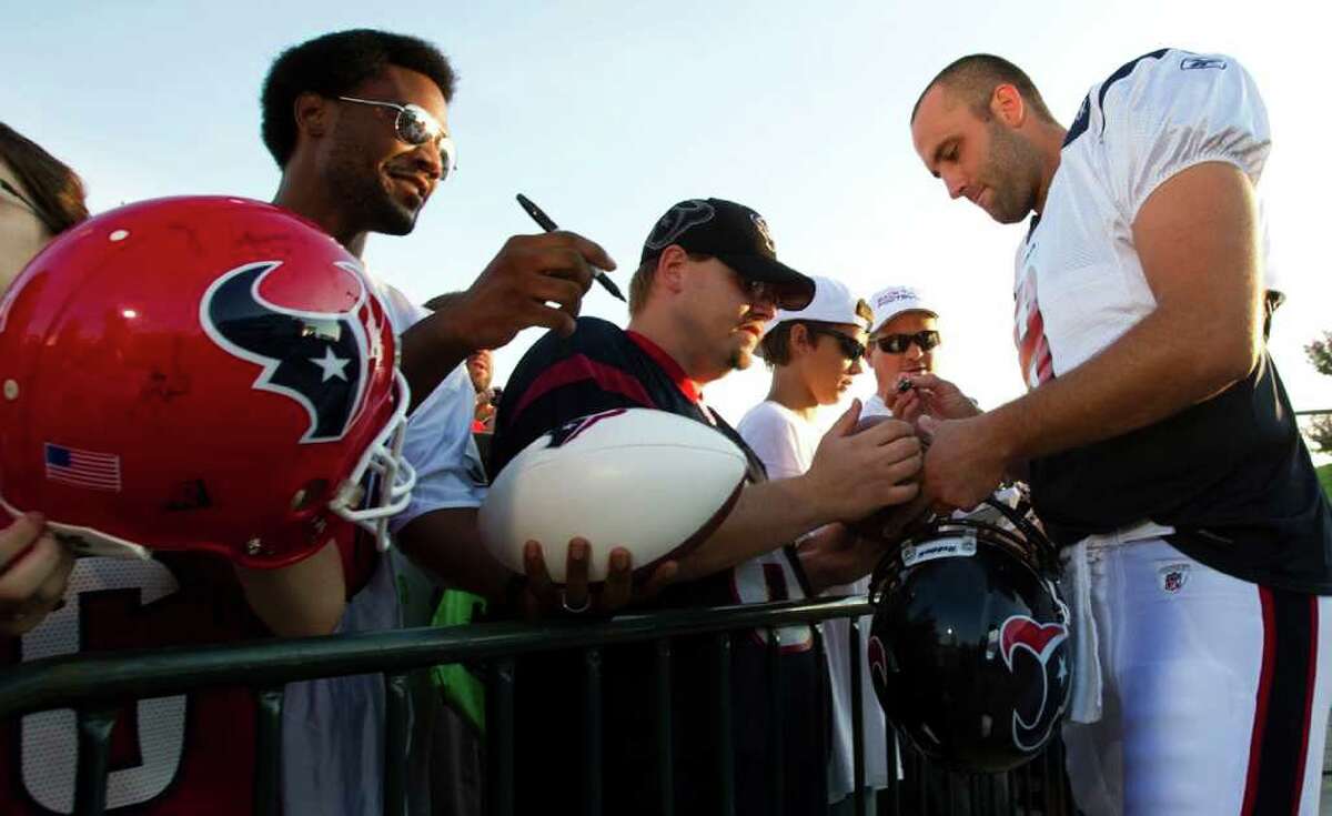 Houston Texans quarterback Matt Schaub, right, signs autographs for fans as he arrives for an NFL football training camp Saturday, Aug. 6, 2011, in Houston.