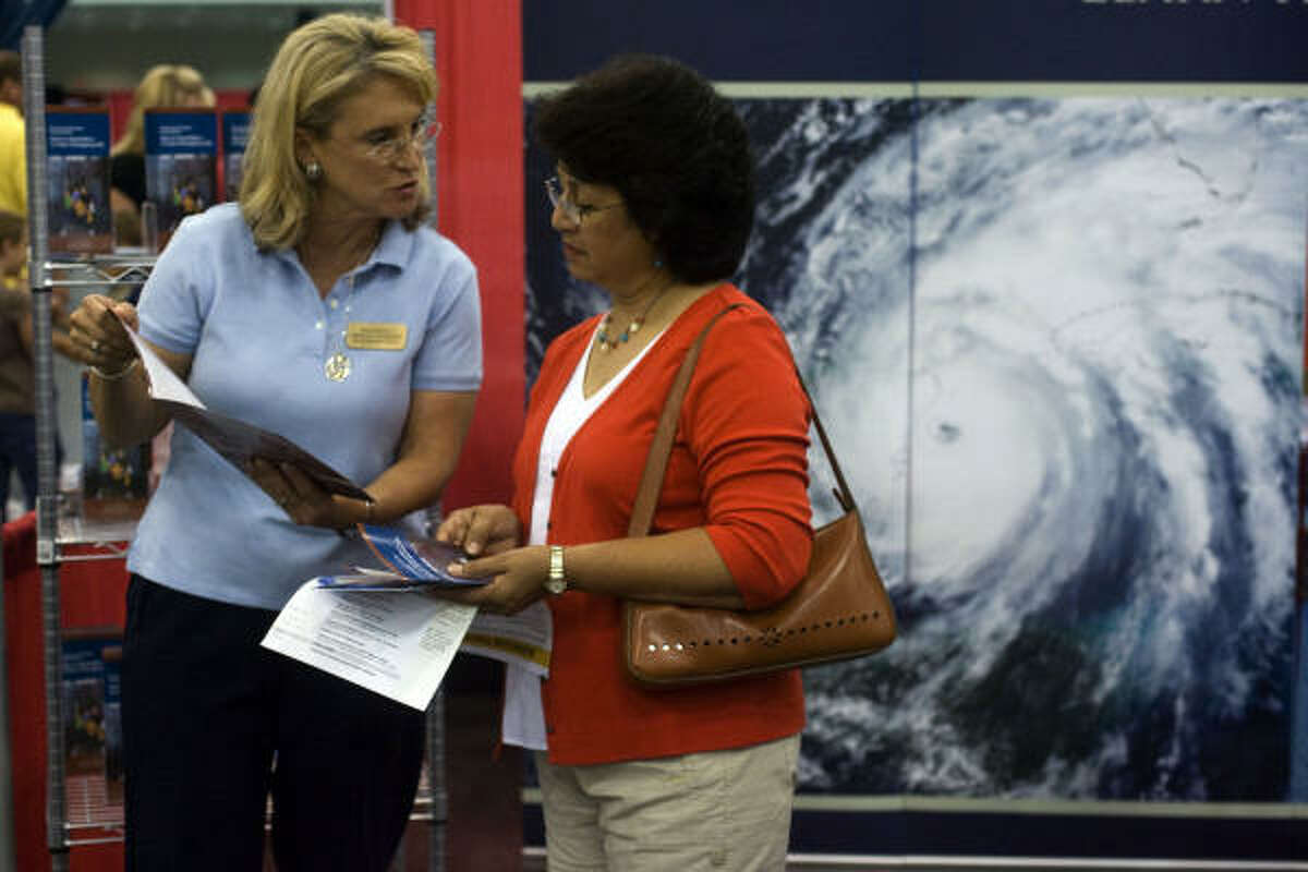 Gloria Parker of Friendswood is given a 72-hour emergency preparedness brochure from Lesley Hagen, with The Church of Jesus Christ of Latter-Day Saints at the 2009 Hurricane Workshop held at the George R. Brown Convention Center.