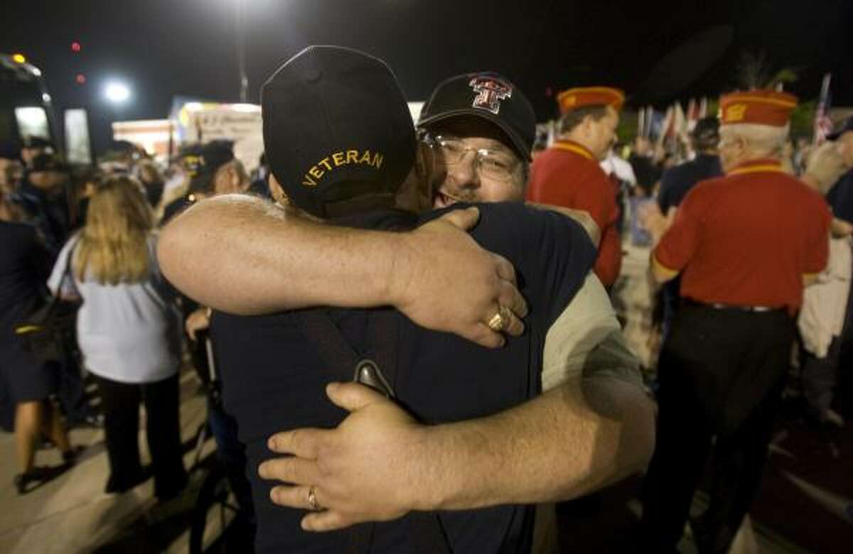 WWll veteran Jim Dacus, 86, of Richardson who served in the Navy, is hugged by friend, Ike Cegielski of Conroe before Dacus departed for the airport.