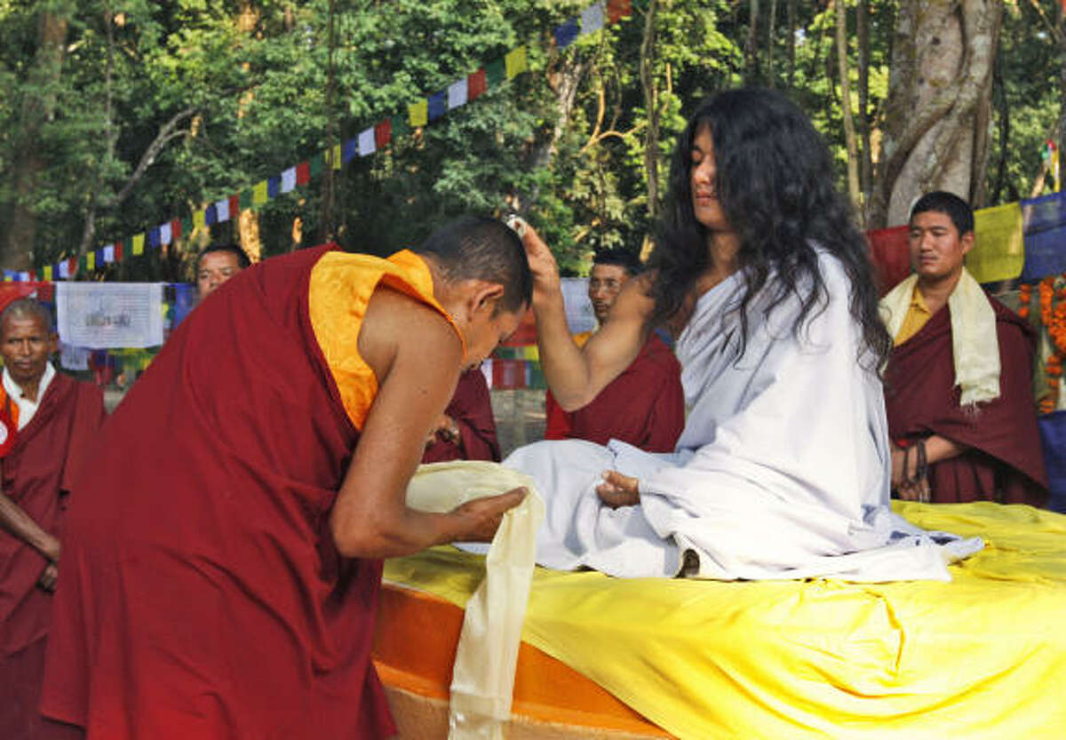 Ram Bahadur Bamjan, in white, believed to be the reincarnation of Buddha, blesses a Buddhist monk in Nijgadh town, about 160 kilometers (100 miles) south of Katmandu, Nepal, Wednesday, Nov. 12, 2008. After retreating into the jungle in southern Nepal for more than a year, Bamjan, 18, re-emerged and began attracting thousands of devotees.