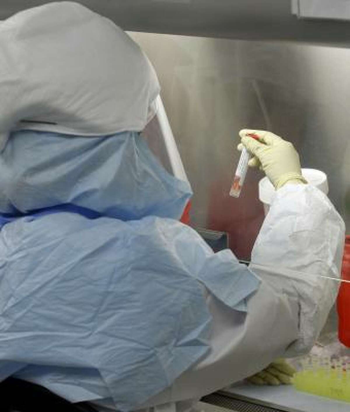 Lead scientist Lupe Garbalena handles a sample while testing for swine flu at the Houston Department of Health and Human Services.