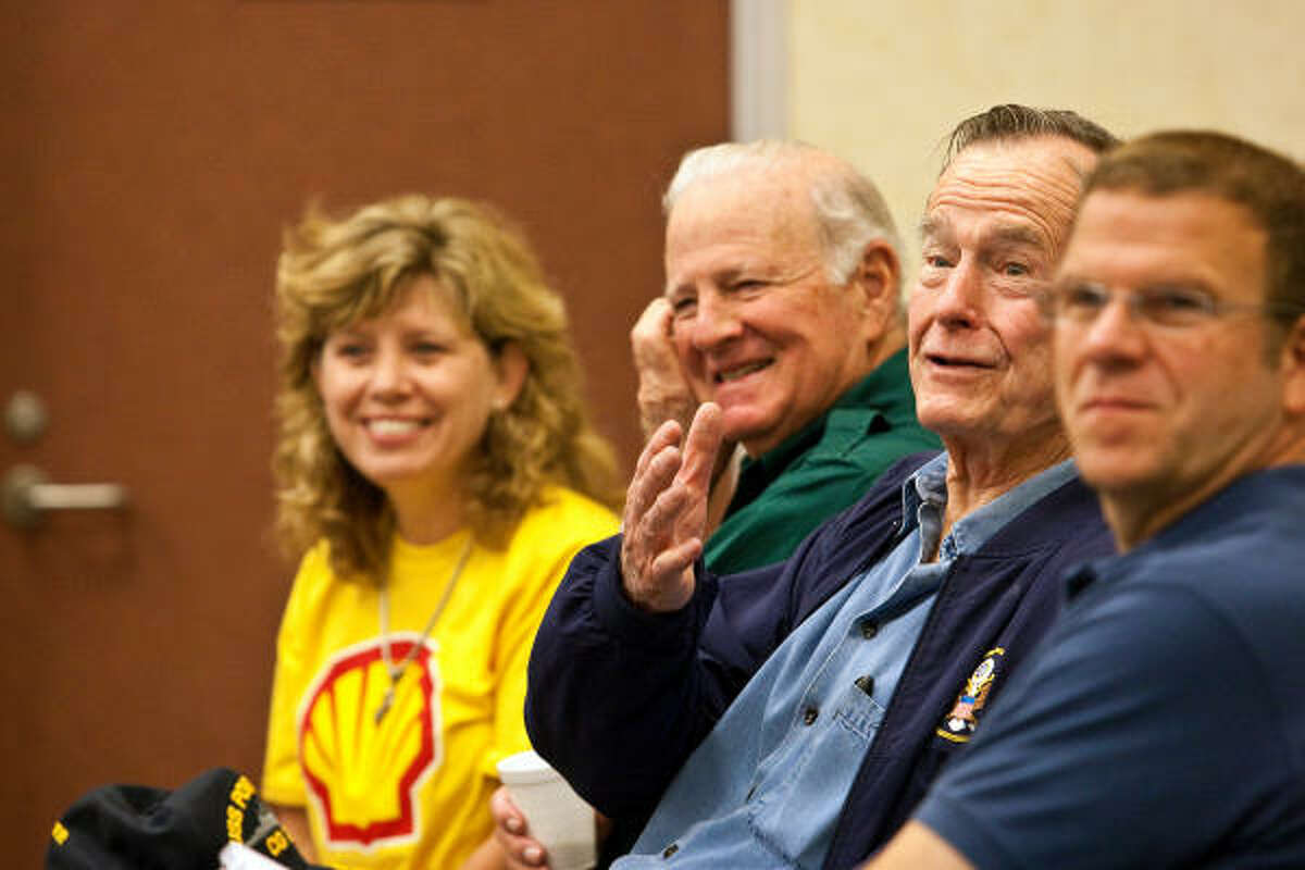 Former President George W. Bush shares a story with Galveston County officials along with former secretary of state, James Baker, left, and local business owner, Tillman Fertitta, right, prior to kicking off a massive cleanup,on Crystal Beach.