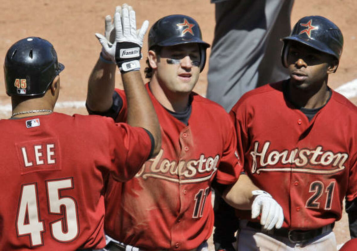 Lance Berkman, center, is greeted by teammates Carlos Lee and Michael Bourn after his homer.