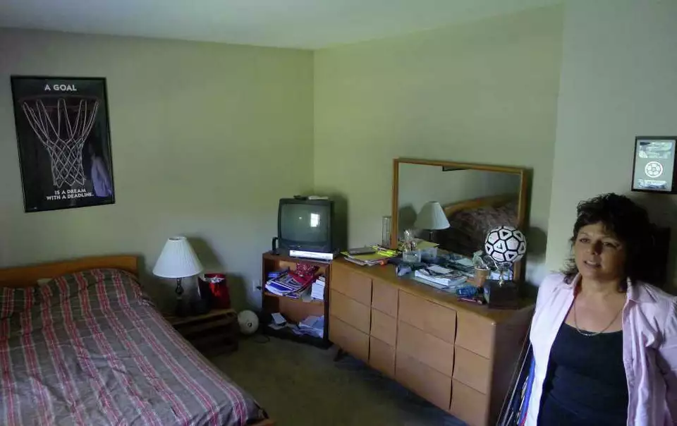 Veronica Frear standing inside the preserved bedroom of her missing son, Craig Frear.