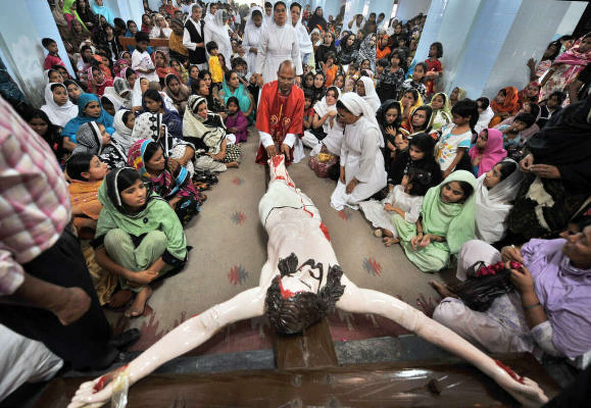 Pakistani Christian devotees gather around a scene depicting the crucifixion of Jesus Christ as they attend a Good Friday service at the Saint Francis Church in Lahore on April 10, 2009. Christian believers around the world mark the Holy Week of Easter in celebration of the crucifixion and resurrection of Jesus Christ.