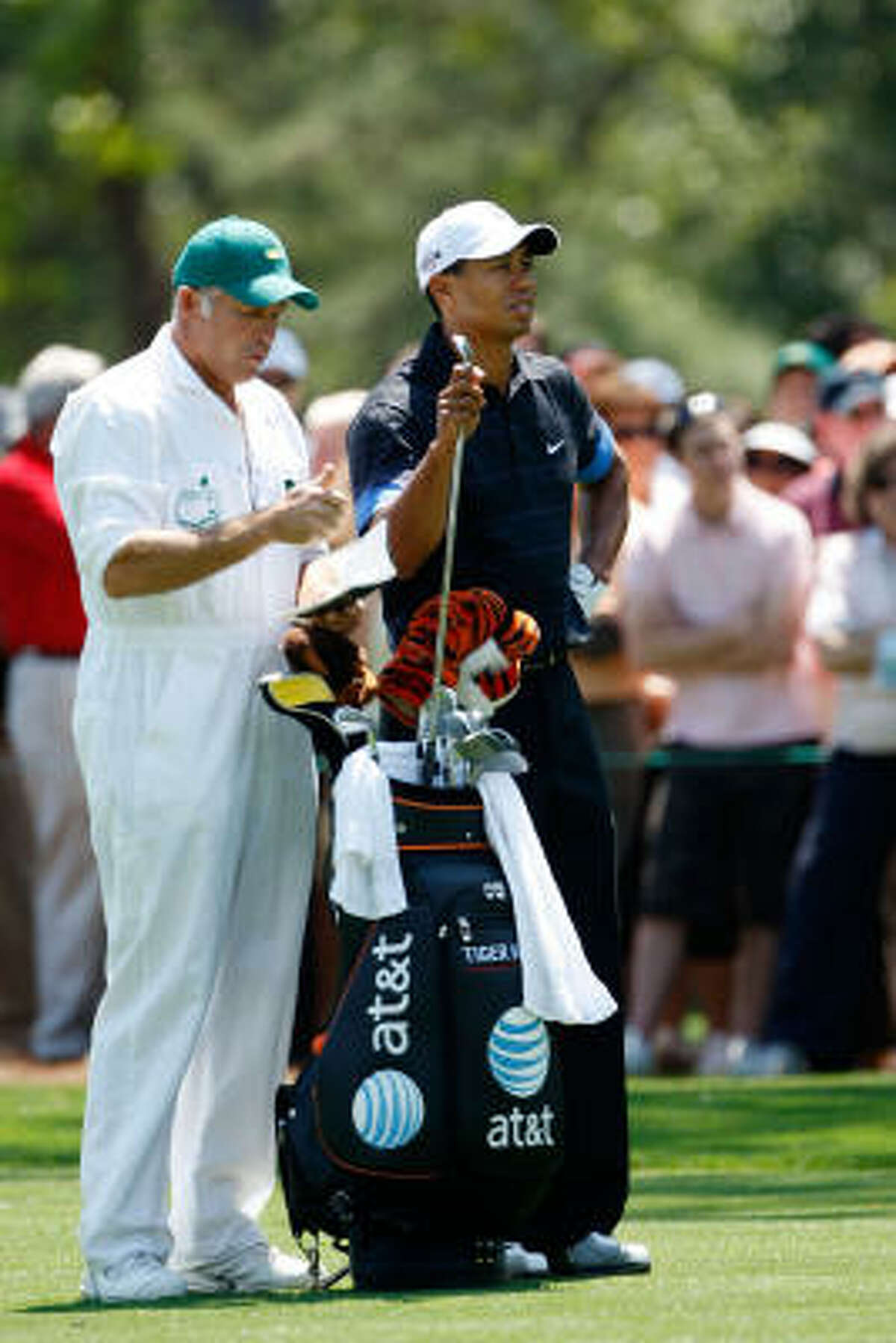 Tiger Woods waits in the first fairway as his caddie Steve Williams looks on.