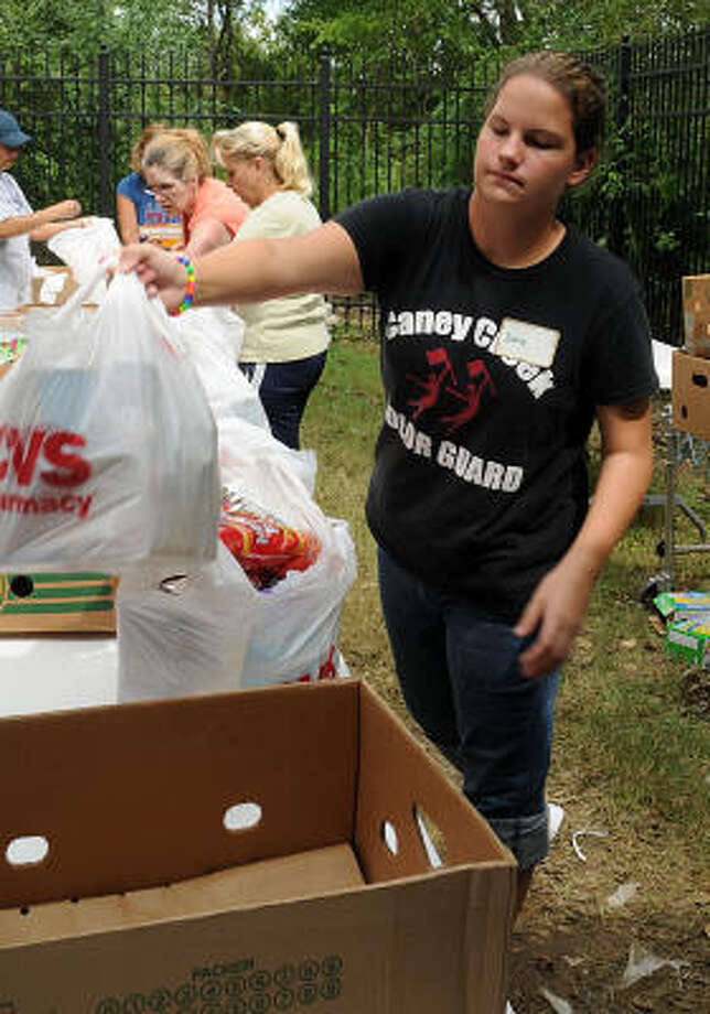 Caney Creek High School student Emily Jones fills a sack with food at the Montgomery County Food Bank. Photo: David Hopper, For The Chronicle