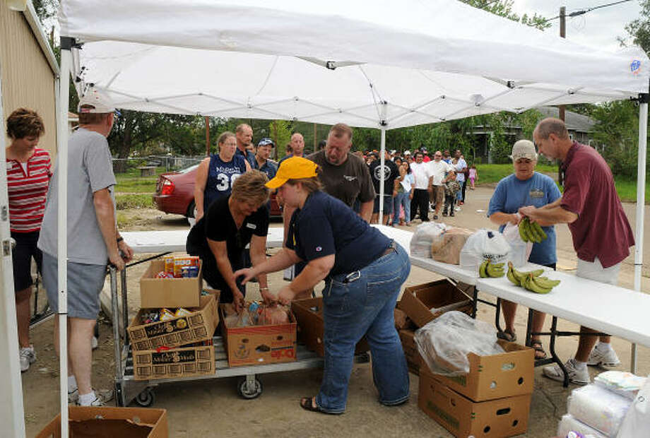 Volunteers hand out food at the Montgomery County Food Bank in Conroe. The Food Bank was serving almost 1000 walk up storm victims at the Food Bank location. Photo: David Hopper, For The Chronicle