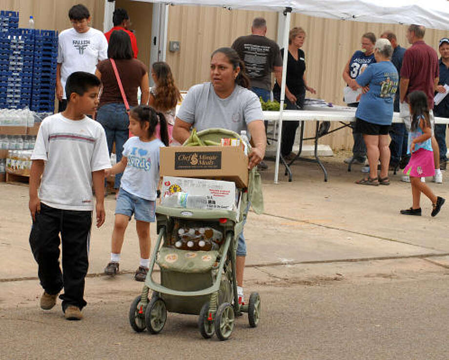 A family leaves the Montgomery County Food Bank with food carried in a baby carriage. Photo: David Hopper, For The Chronicle