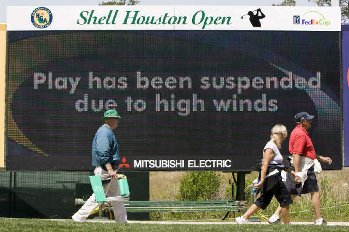 Golf fans walk off the course as play was suspended because of high winds during the first round at Redstone Golf Club.