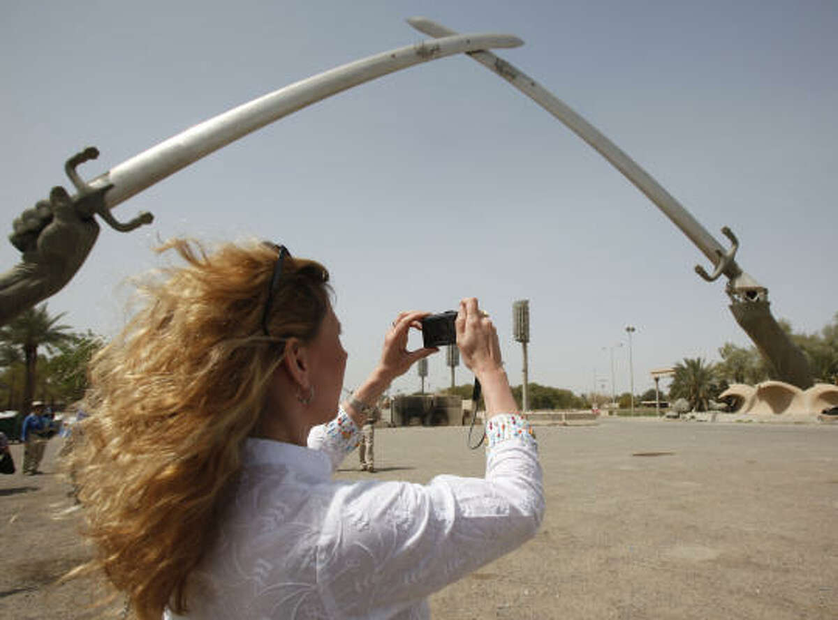Tina Townsend Greaves, from the U.K., takes a photo of the crossed swords monument in Baghdad's Green Zone on Saturday.