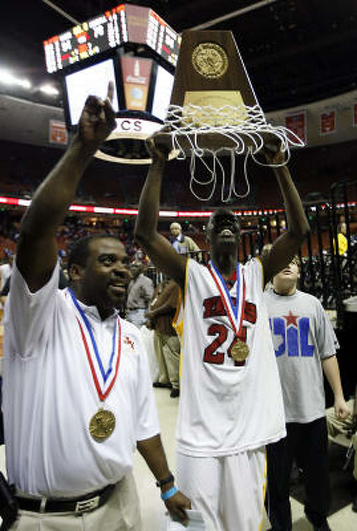 Yates guard Brandon Williams (24) holds up the 4A trophy to the Lions fans after beating Dallas Kimball 94-78.