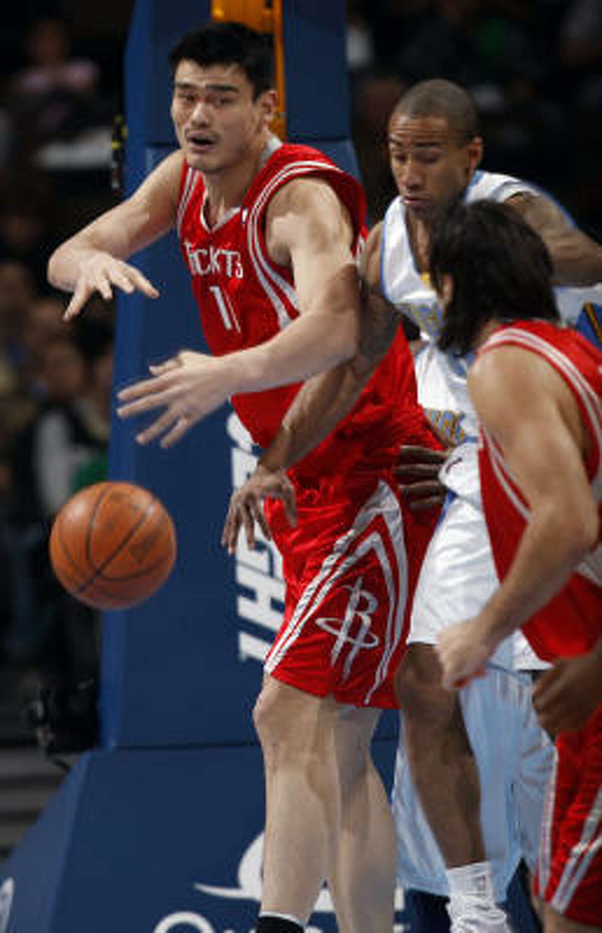 Rockets center Yao Ming, left, loses control of the ball after pulling down a rebound in front of Nuggets guard Dahntay Jones, back right, and Rockets forward Luis Scola in the first quarter.