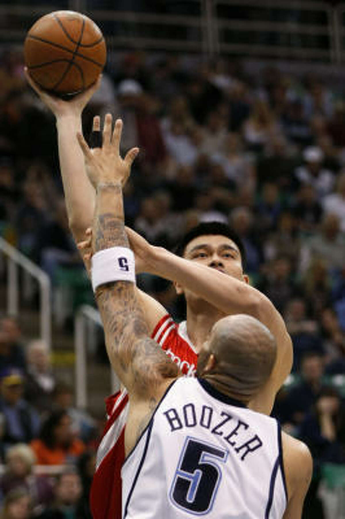 Yao Ming, back, shoots over Jazz forward Carlos Boozer in the first half.