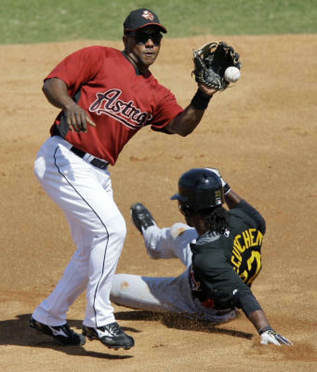 Astros shortstop Miguel Tejada, left, catches the throw from the catcher as Pittsburgh Pirates' Andrew McCutchen, right, steals second base.