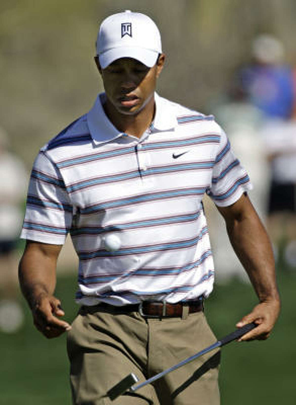 Tiger woods flips his ball to himself as he walks off the green after losing the 13th hole during his 4 and 2 loss to Tim Clark in the second round of the Accenture Match Play Championship on Thursday.