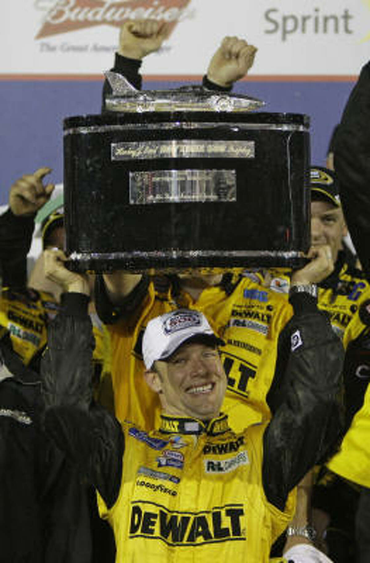 Matt Kenseth holds up the trophy as he celebrates with his crew in victory lane after winning the rain-shortened Daytona 500.