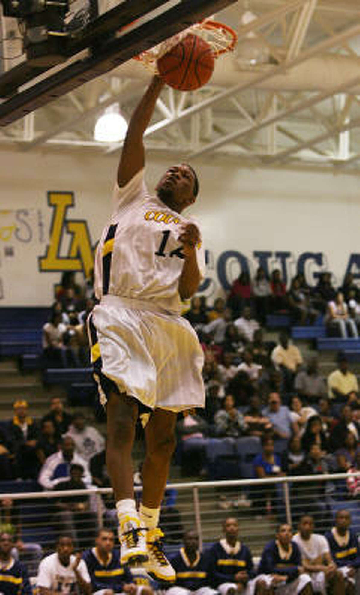 La Marque's Junen Lewis slams dunks in the 3rd Period during the basketball game at La Marque.