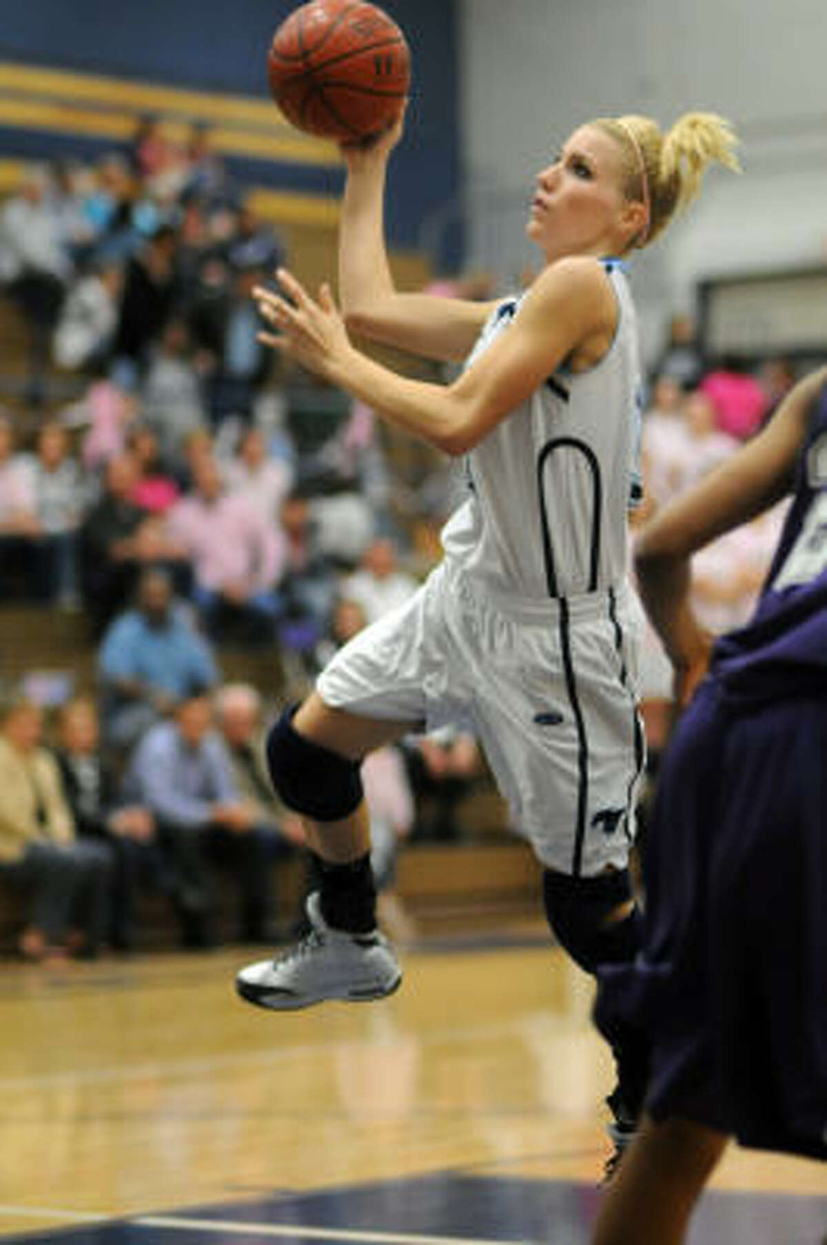 Kingwood senior Ashley Wiens (34) drives to the hoop against Humble.