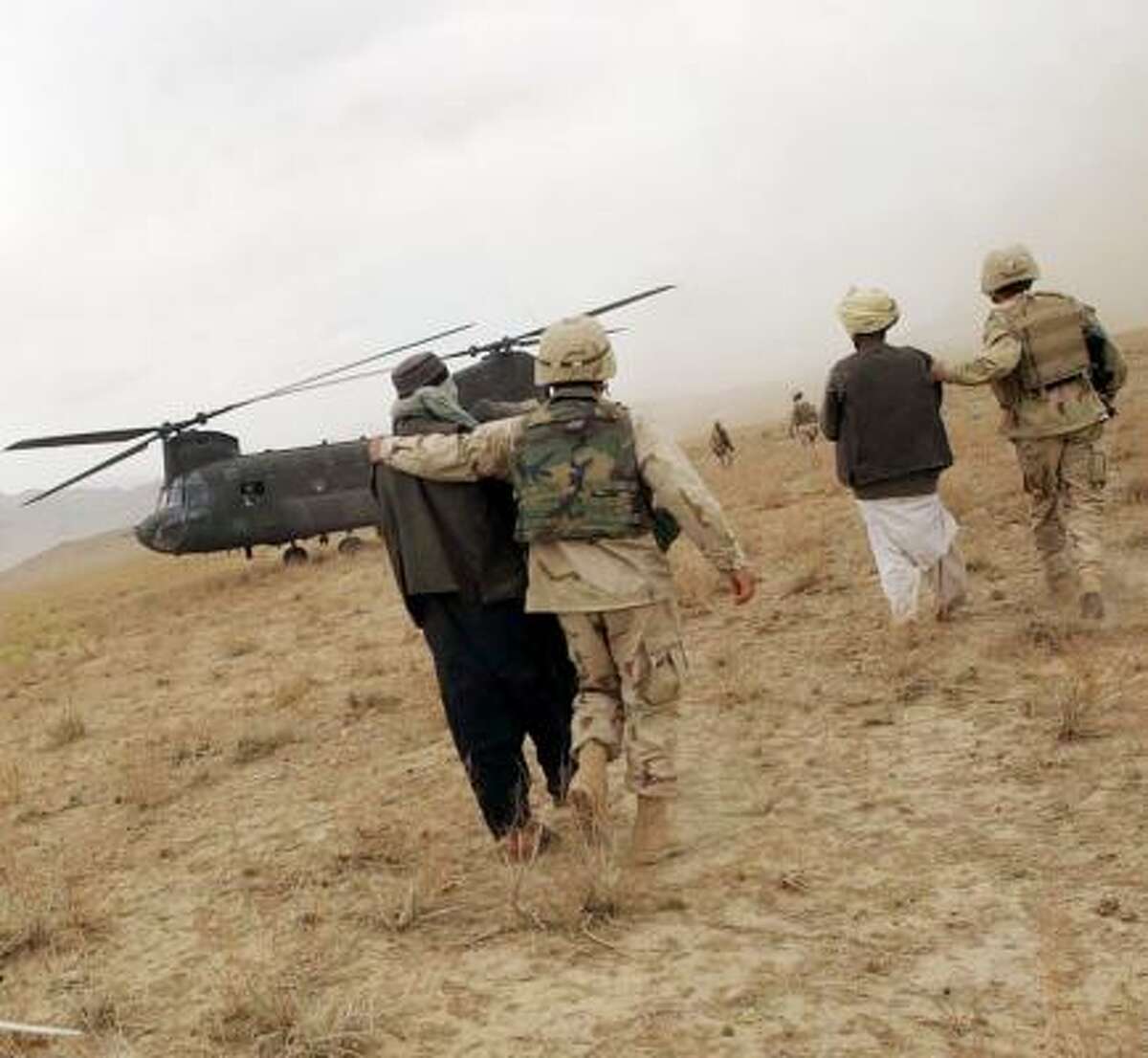 Afghan detainees are led to a helicopter by U.S. forces in Taxi to the Dark Side.