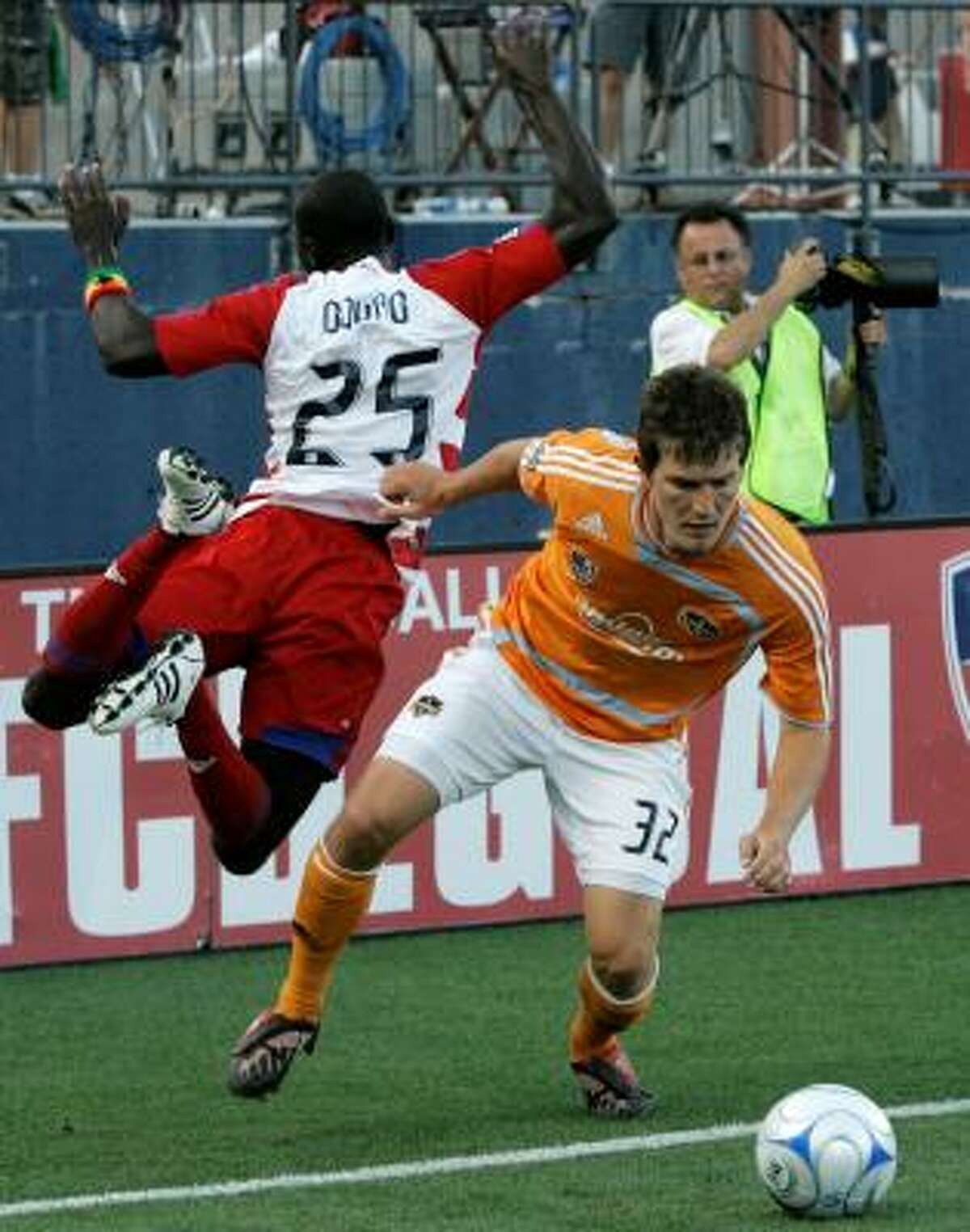 FC Dallas forward Dominic Oduro, left, is knocked out of bounds by Dynamo defender Bobby Boswell as they compete for a loose ball in the first half.