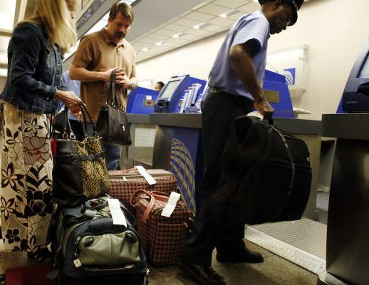 Skycap Robert Bernard helps Brenda and Eric Cooper check in their luggage at the Continental counter at Bush Intercontinental Airport on Friday. Airlines are hoping to cut down on luggage, which will help to conserve fuel.
