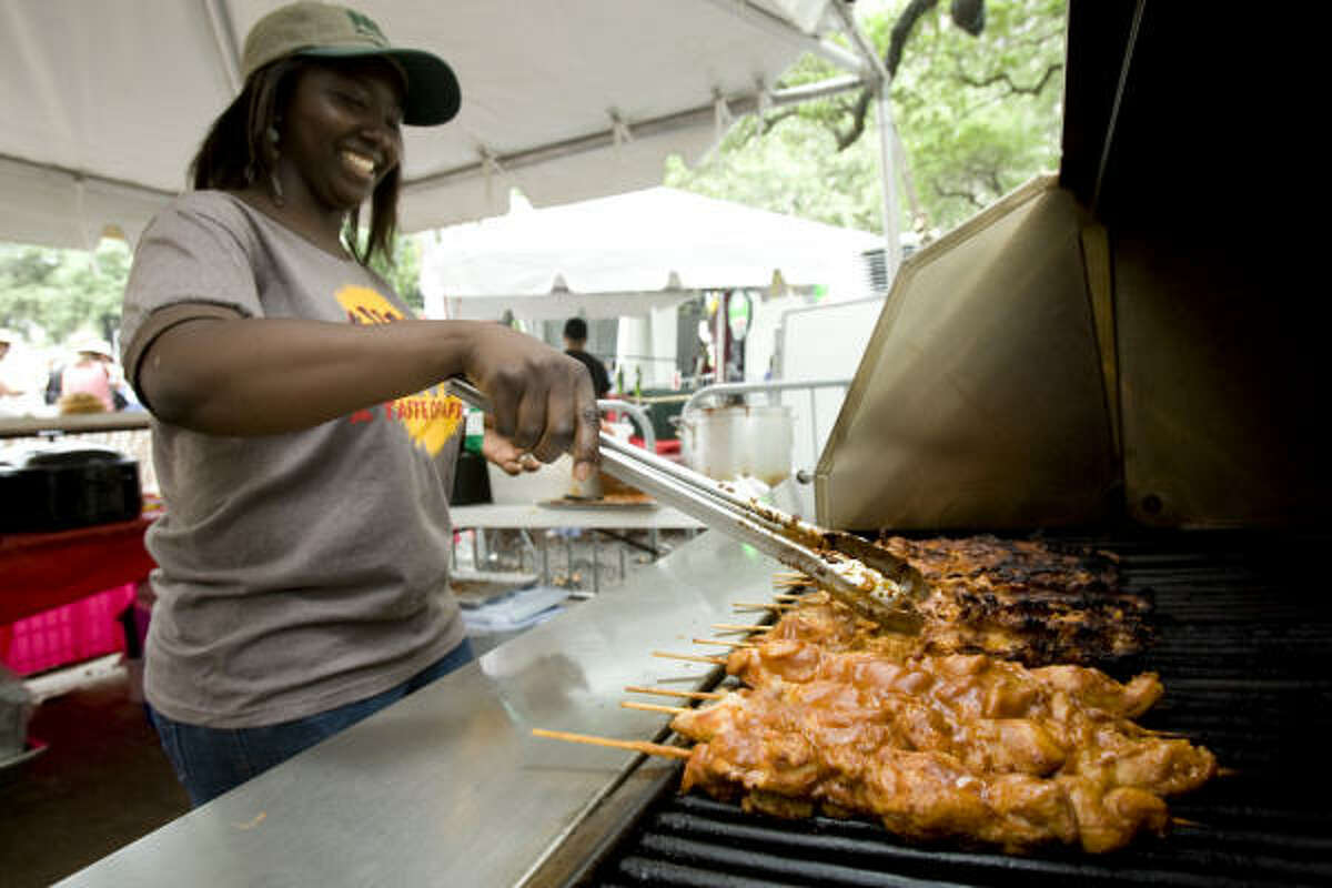 Janada Yarida cooks chicken suya at the Suya Hut during the Houston International Festival.