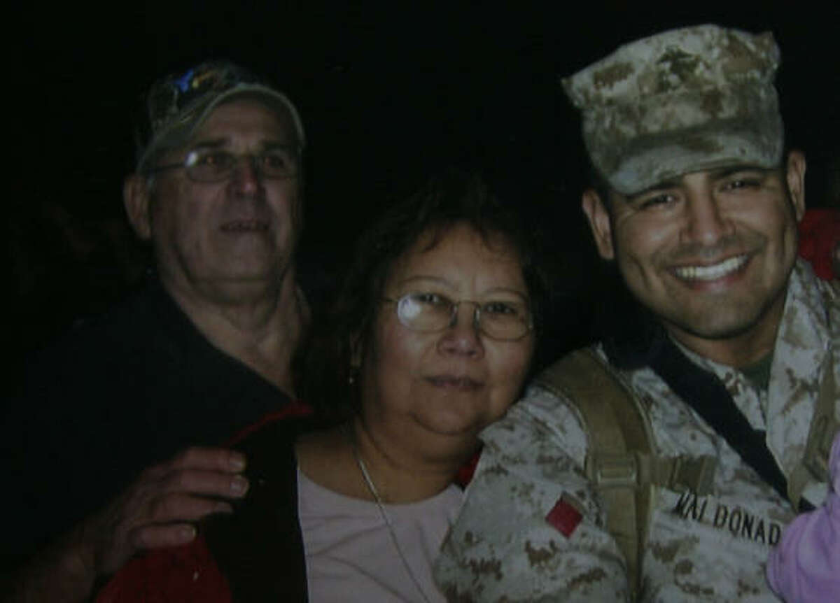 A family photo shows Gloria McInnis, 55, with her husband, Raymond McInnis, left, and her son, Jose Angel Maldonado, who is on his second tour in Iraq. Gloria McInnis was killed in an explosion Wednesday at the Goodyear plant in southeast Houston, where she had worked for 31 years.