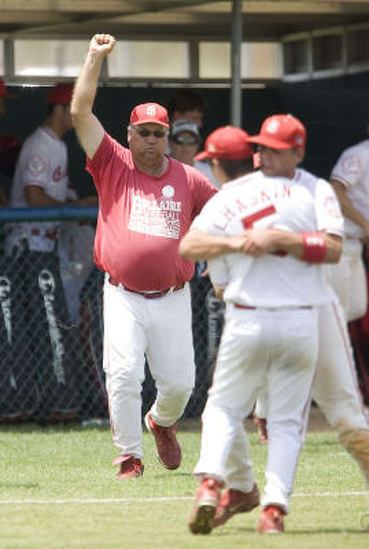 Bellaire head coach Rocky Manuel celebrates with his players after the last out during Game 2 of the Class 5A regional final Saturday. Bellaire won 2-0, forcing a Game 3.