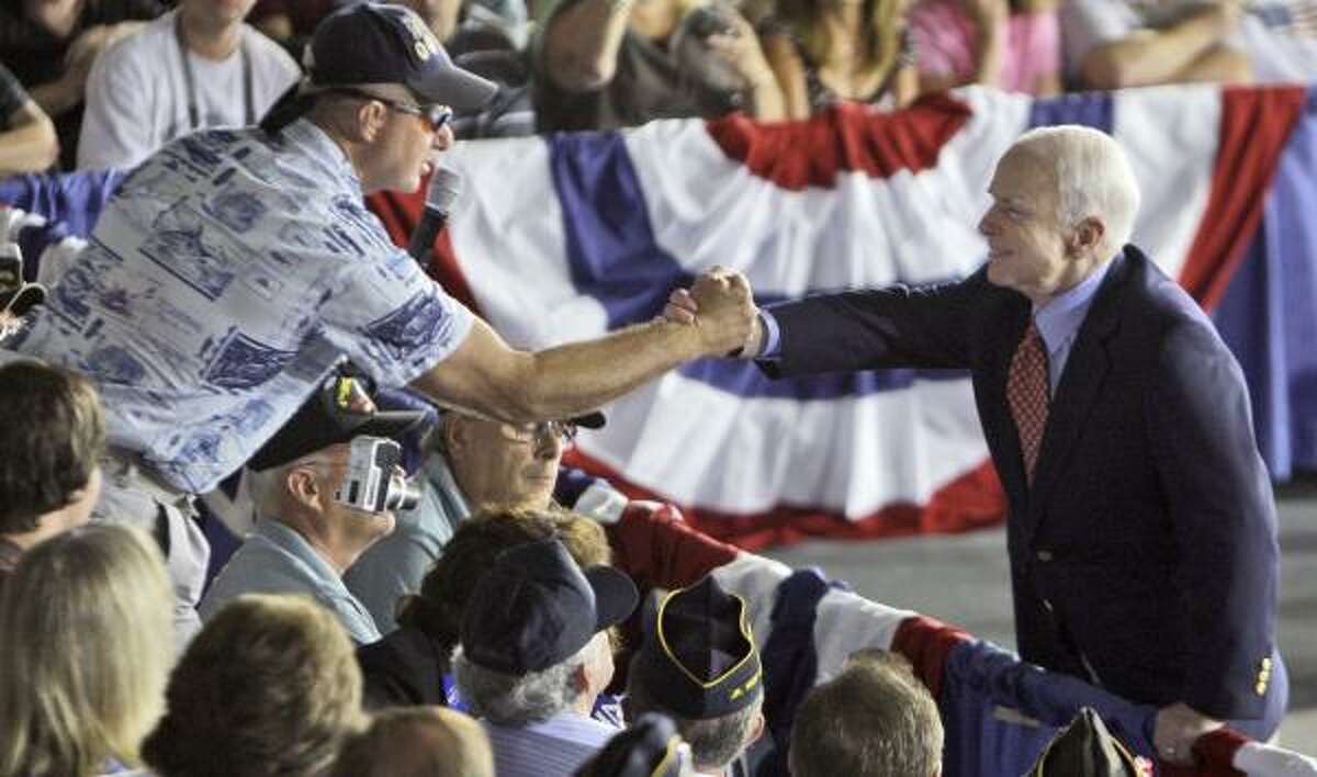John McCain shakes hands with a supporter in Pemberton, N.J., where he went solo to his first town hall meeting.