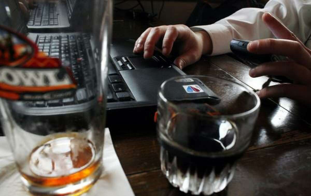 An information technology salesman who didn't want to be identified checks his phone and works on his laptop while enjoying a drink at the Stag's Head Pub.