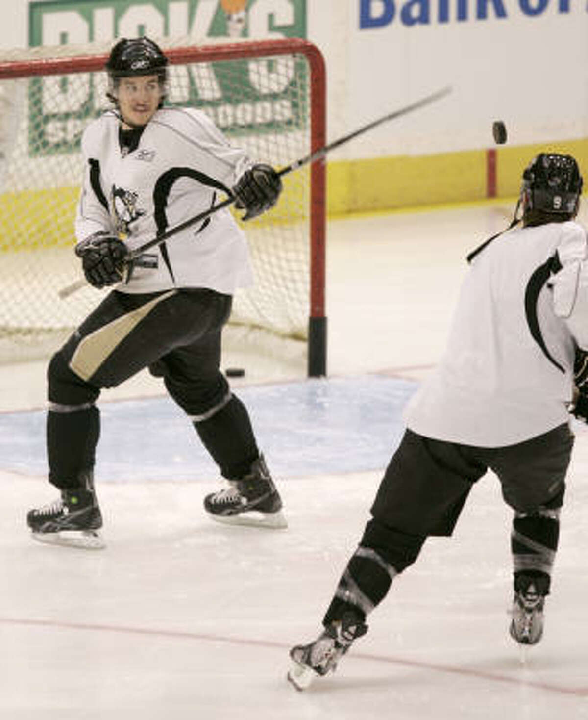 Pittsburgh Penguins' Sidney Crosby,left, swats at a puck flipped up by teammat Pascal Dupuis as the two warm up before practice in Pittsburgh, on Wednesday. The Penguins face the Detroit Red Wings in the Stanley Cup Finals first game on Saturday in Detroit.