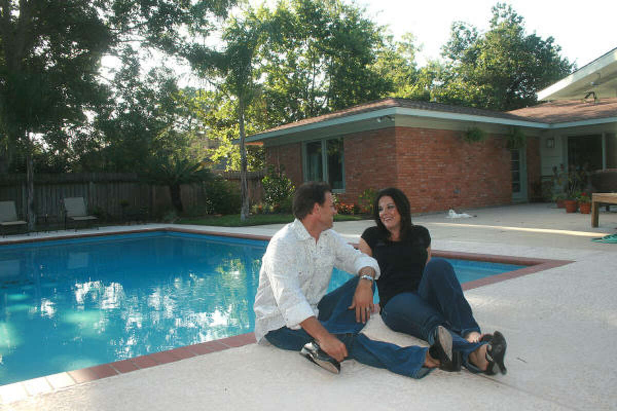 Chris and Lindsey Kimble enjoys the morning sun briefly in the the backyard pool at their newly renovated home in the Glenbrook Valley subdivision near Hobby Airport.