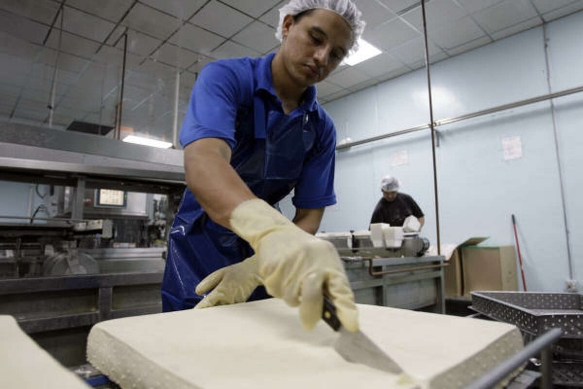 Ramon Torres cuts tofu at Banyan Foods. In 2005, the Chiu family began making tamales of tofu instead of more traditional fillings like chicken, pork and beef.