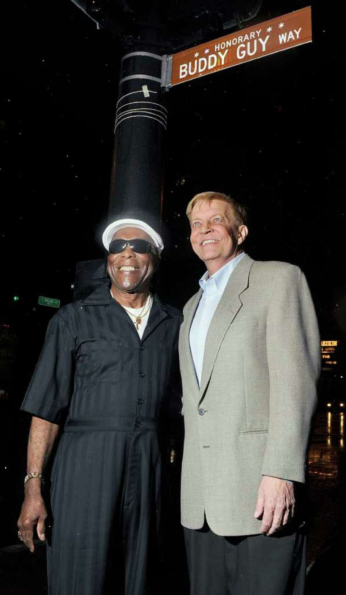 In this photo taken Sunday, Aug. 7, 2011, blues legend Buddy Guy, left, stands under an honorary street sign on his honor with Chicago Alderman Robert Fioretti outside Guy's Legends music club in Chicago. (AP Photo/Chicago Sun-Times, Tom Cruze) CHICAGO LOCALS OUT, MAGS OUT